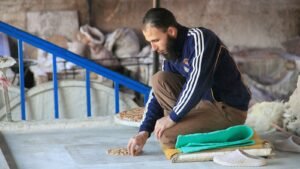 Marokkanischer Kunsthandwerker bei der Arbeit an traditionellen Zellij-Mosaikfliesen