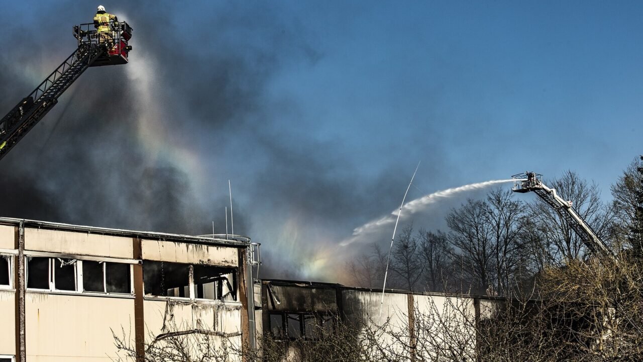 Feuerwehrleute löschen einen Großbrand in einer Fabrikhalle (Symbolbild)