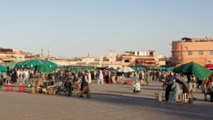 Belebter Jemaa el-Fnaa in Marrakesch mit Touristen und Marktständen