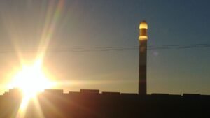 Solarturm des Noor-III-Kraftwerks bei Ouarzazate im Gegenlicht der untergehenden Sonne
