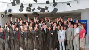 Absolventinnen und Absolventen werfen bei einer MBA-Abschlussfeier ihre Doktorhüte in die Luft (Symbolbild)