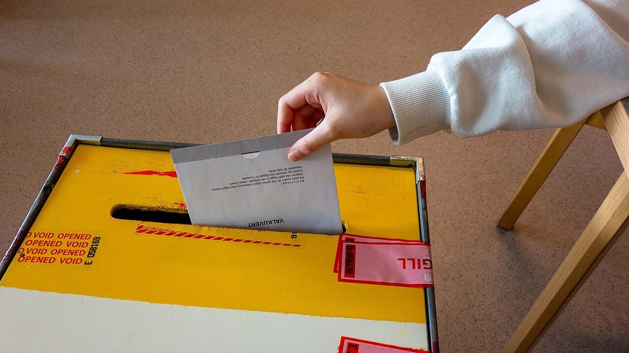 Hand wirft Stimmzettel in eine Wahlurne (Symbolbild)