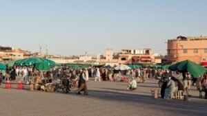 Marktstände und Besucher auf dem Platz Djemaa el-Fna in Marrakesch am Abend